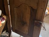 a wooden cabinet with a door open in the corner of a room