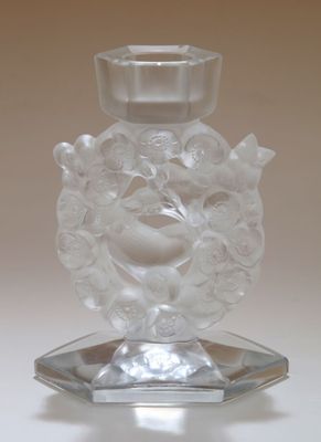 un bougeoir en verre transparent orné d'un oiseau