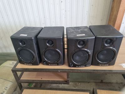 three speakers are sitting on top of a table in a room
