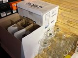 boxes of empty wine glasses on a wooden table in a room