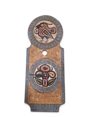 une horloge sur laquelle figure un oiseau et qui comporte un autre oiseau au dos