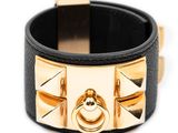 leather cuff bracelet with gold rivets and studs on a white background