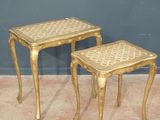 une paire de tables d'appoint en or avec des tabourets assortis, posées sur un sol recouvert de moquette