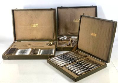 quatre pièces d'argenterie dans un coffret posé sur une surface blanche
