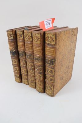 plusieurs vieux livres sont empilés sur une surface blanche
