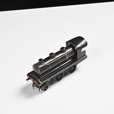 un petit train sur une surface blanche avec un fond noir