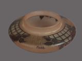 a small vase with a design on it on a gray background