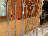 four coat racks with umbrellas on them in front of a building