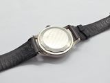 wrist watch on a black leather strap with a white dial