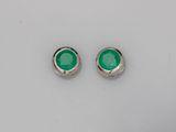 une paire de boucles d'oreilles à clous en verre vert posées sur une surface blanche