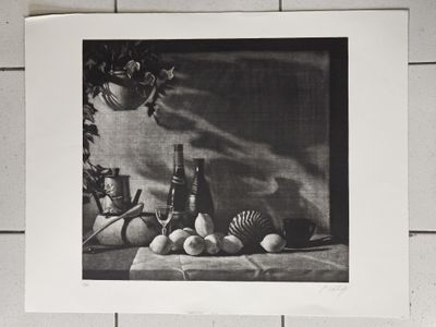 une photo en noir et blanc représentant une nature morte composée de fruits et d'une bouteille