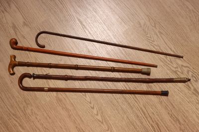 Plusieurs vieilles cannes sont alignées sur un plancher en bois