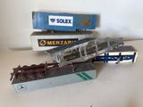 trois camions miniatures posés les uns à côté des autres sur une table