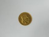 a close up of a gold coin on a white surface