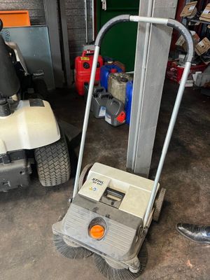 a lawn mower and a mower cart in a garage