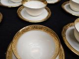 a lot of white and gold plates and bowls on the table