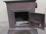an old stove with a door open on a sidewalk