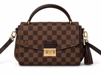 a brown and black handbag with a tassel on top of it