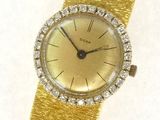 an image of a gold wrist watch with a diamond bezeled bezel