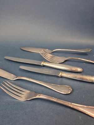 quatre fourchettes et un couteau posés sur une table avec un fond bleu