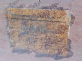a rusted piece of wood with a sign on it