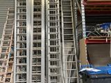 de nombreuses échelles métalliques empilées dans un local de stockage