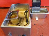 a metal pan with a liquid in it next to a digital device