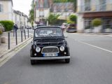 a small black car driving down the street in the city