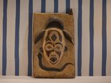 a picture of a wall hanging with a mask on it