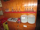 many plates and glasses sitting on a shelf in the kitchen