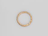 gros plan d'une bague en or sur une surface blanche