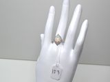 une bague sur la main d'un mannequin, à laquelle est accrochée une étiquette