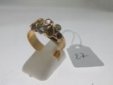 une image représentant une bague en or sertie de pierres bleues et roses