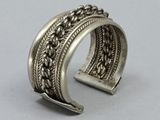 a close up of a silver bracelet on a white surface