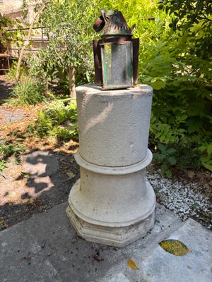 a small lantern sitting on top of a stone pillar