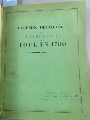 un vieux livre à la couverture verte posé sur une table