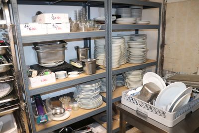 beaucoup d'assiettes et de casseroles sur les étagères de la cuisine