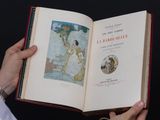 une personne tenant un livre ouvert sur lequel figure une image