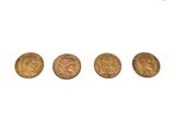 un groupe de quatre pièces d'or posées sur une surface blanche
