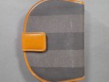 an orange and grey striped wallet with a small leather clip