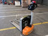une photo d'un chariot élévateur sur le parking d'un entrepôt