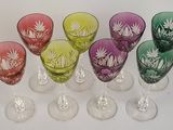 six wine glasses are lined up in a row on a white surface