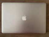 un ordinateur portable MacBook Pro d'Apple posé sur une table en bois