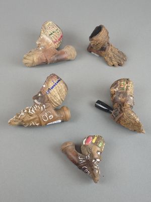 plusieurs paires de chaussures différentes et une pipe posée sur une table