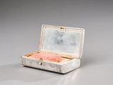 a small white box with a pink object inside of it