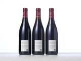 three bottles of red wine sitting on top of a table