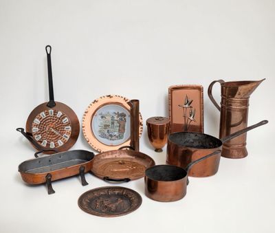 many different types of copper pots and pans on the table