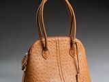 un sac à main en cuir d'autruche marron sur fond gris