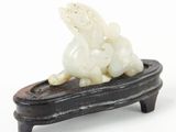 a small figurine of a dog on a wooden stand