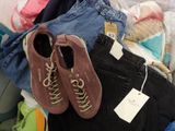 two pairs of shoes that are on top of a pile of clothes